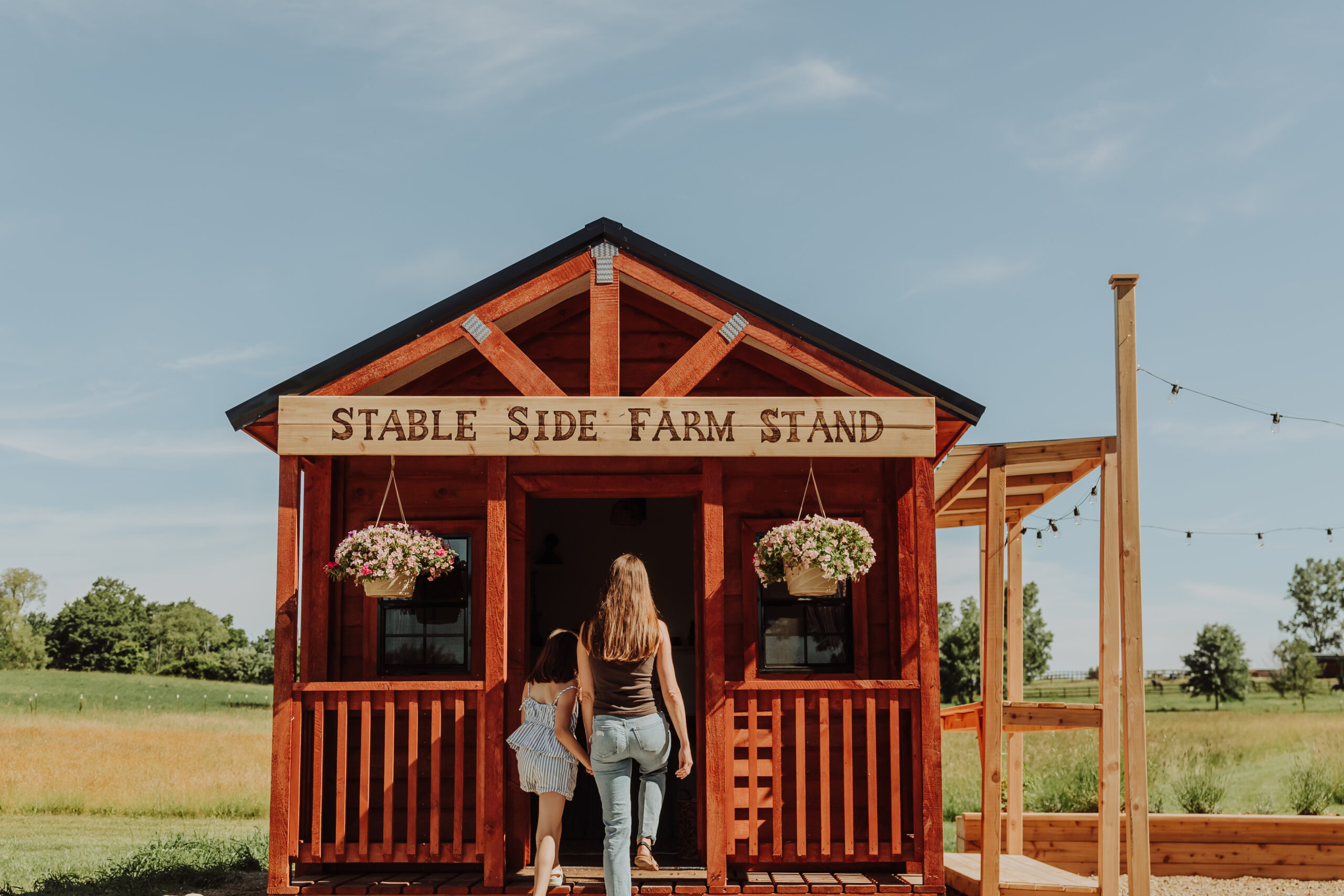 Kelli and her daughter approaching the little red farmstand