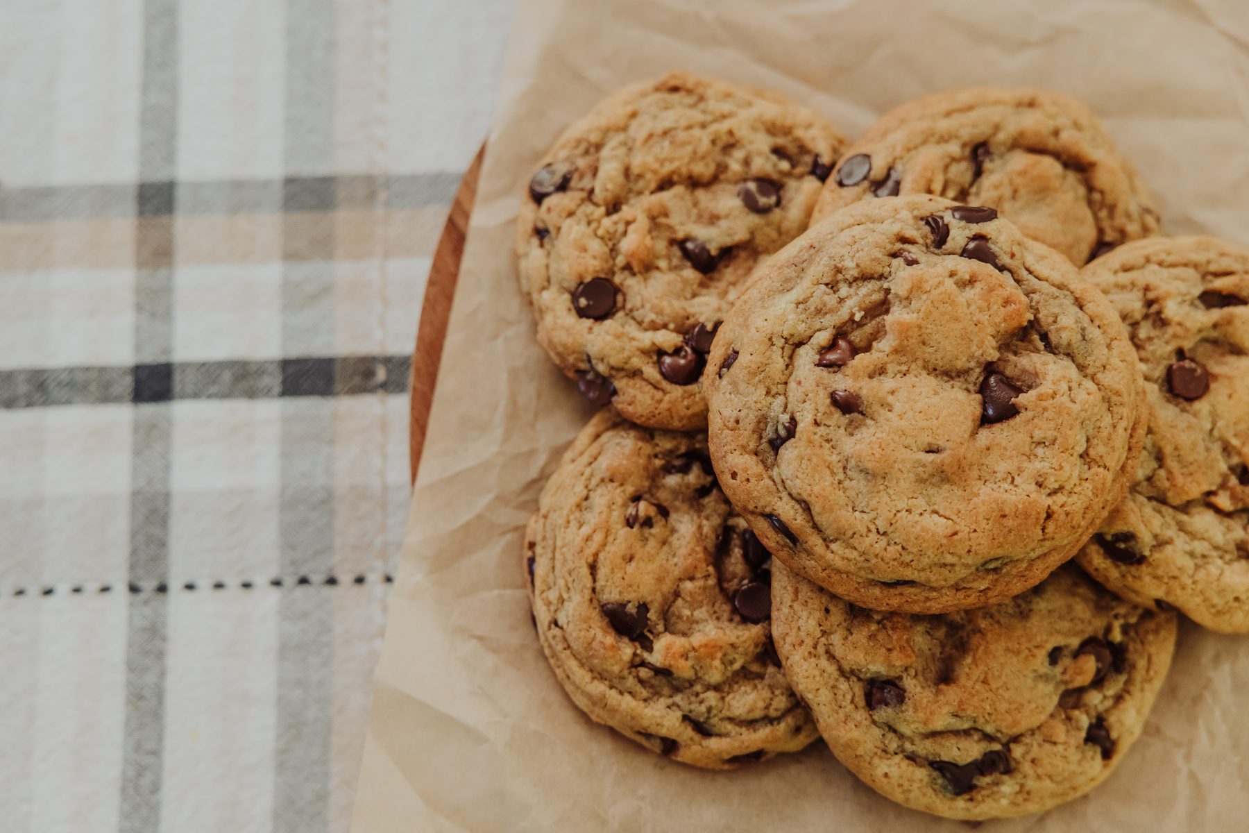 Fresh chocolate chip cookies arranged on a kitchen towel
