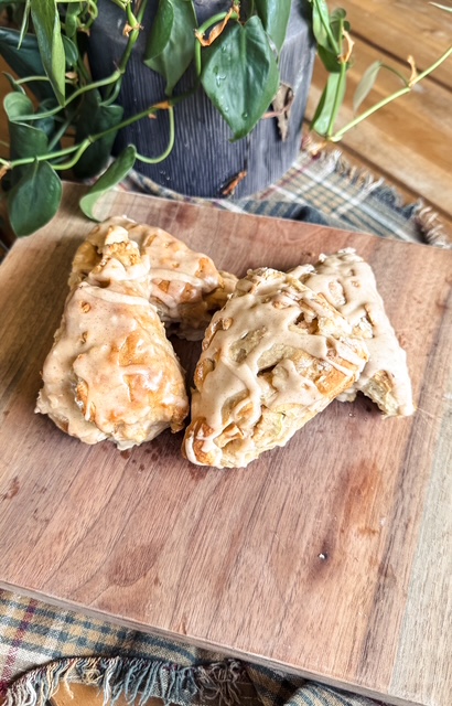 Iced vanilla bean scones on a wooden board